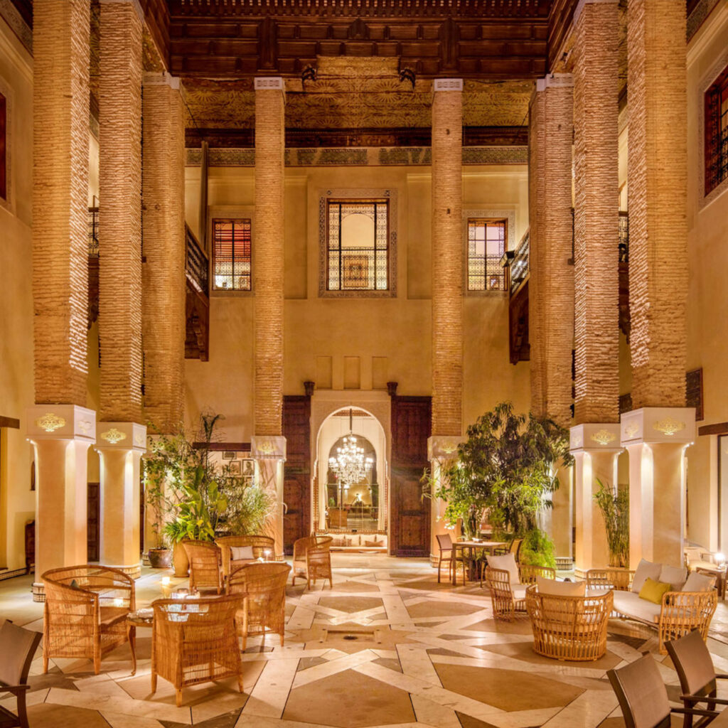 Elegant courtyard inside a luxury Riad in Fez, Morocco, featuring soaring columns and a chandelier
