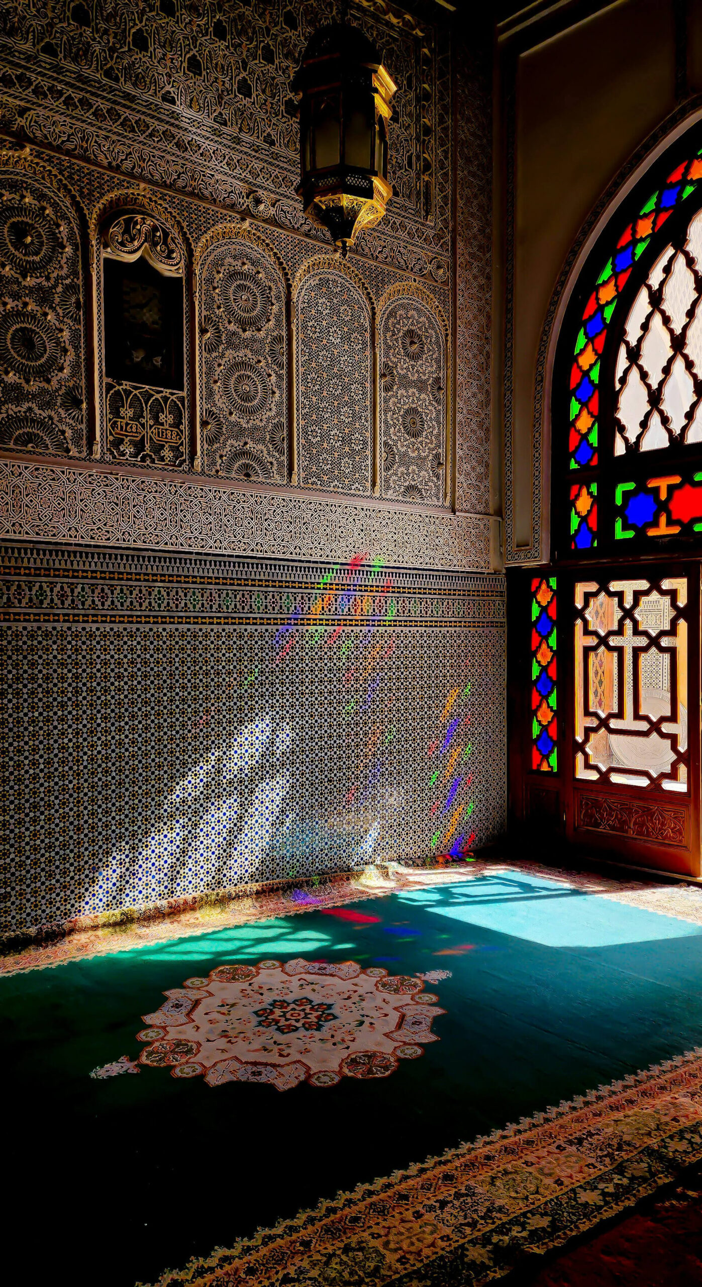 Sunlight casting colorful patterns through stained glass windows in a traditional Moroccan building