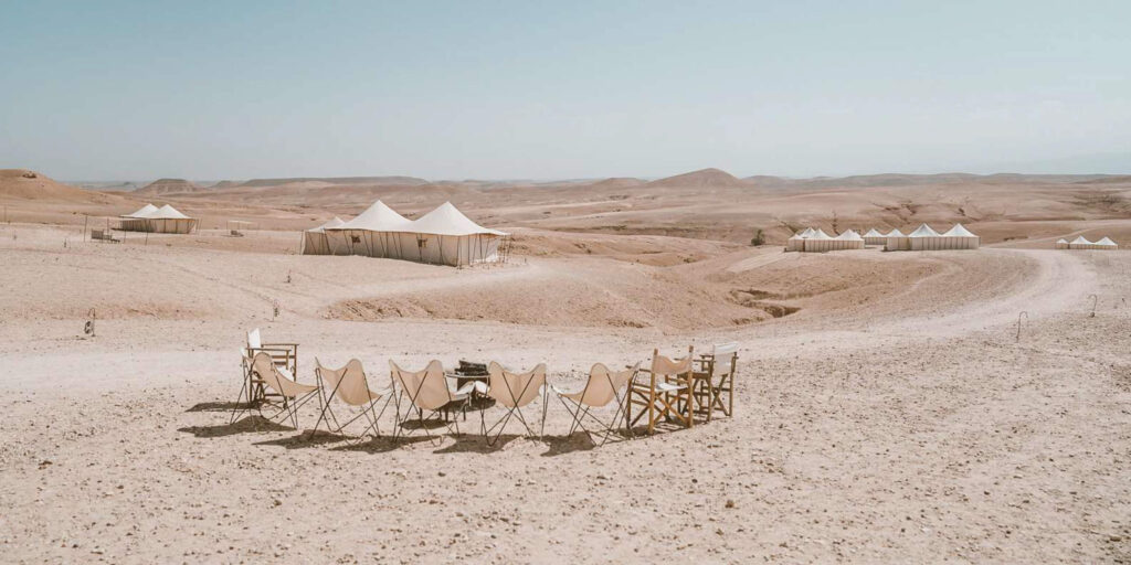 Luxury desert glamping site in the Agafay Desert, Morocco, with canvas tents and director’s chairs