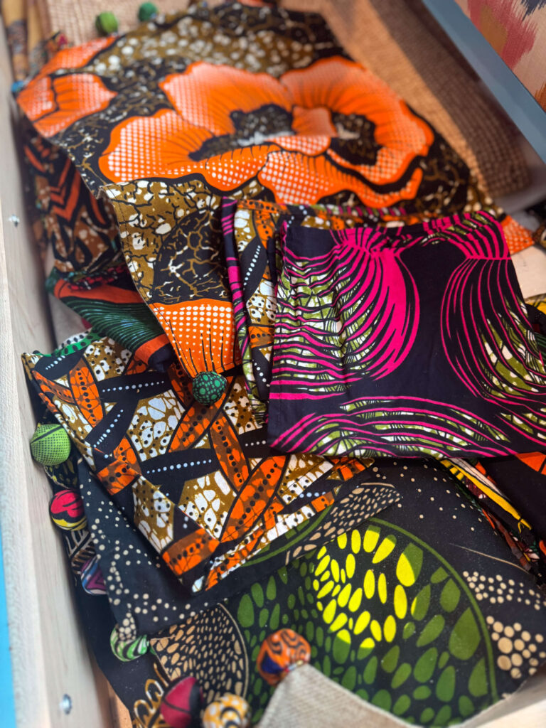 A drawer filled with vibrant African napkins and textiles in bold floral and geometric patterns.